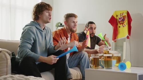 Joyful Football Fans Cheering for Favorite Team While Watching Match on TV Sitting at Home