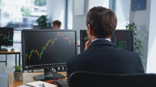 Stock Trader Looking Monitors Analyzing Currency Market Charts in Office Closeup