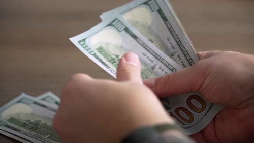 Close-up hands counting money dollars, counting money men's hands.