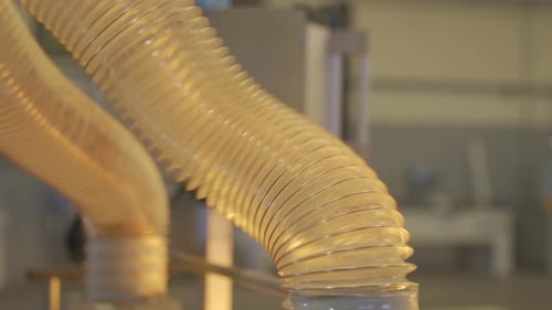 Close up view of flexible duct for industrial extractor working in a factory.