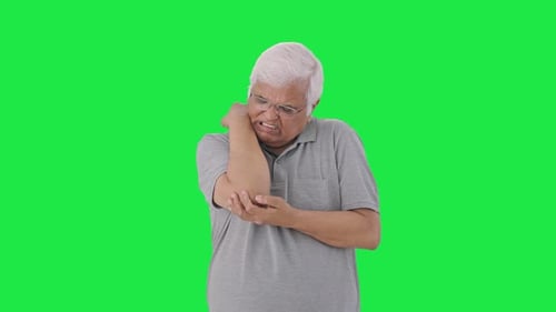 Sick Indian old man suffering from arthritis Green screen