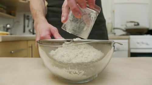 Sifting Flour into Bowl for Baking in Kitchen