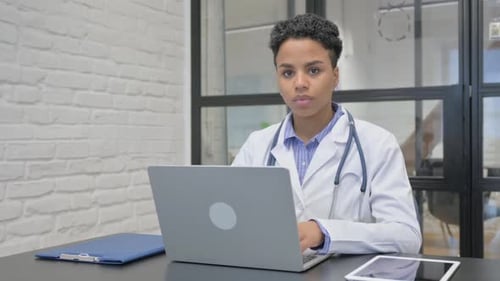 African Female Doctor Smiling at Camera in Clinic