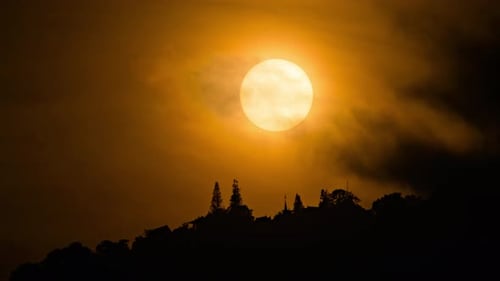Timelapse of dramatic sunset at a mountain with orange sky in a cloudy day.
