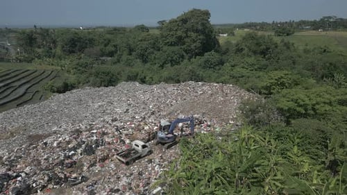 Flyover garbage dump abutting jungle river in lush, green Bali
