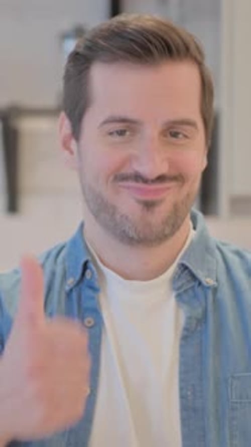 Young Adult Smiling and Giving a Thumbs Up