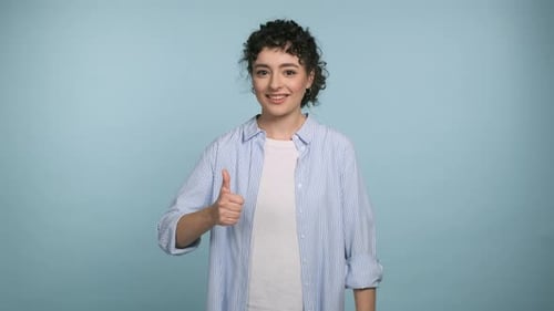 Young Woman Gives Two Thumbs Up in Studio