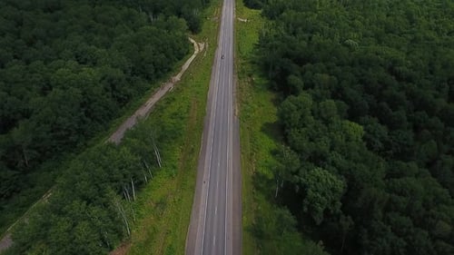 Aerial View Above Cars Driving Along Empty Countryside Road on Sunny Day