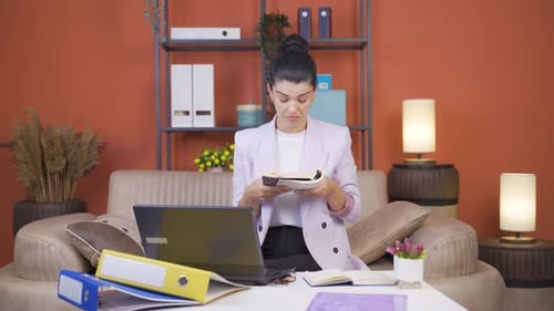 Home office worker young woman reading a book.
