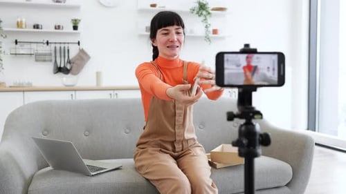 Young Woman Vlogging About Tech Product on Phone