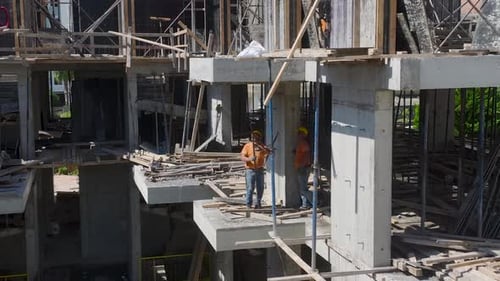 Los trabajadores de vista aérea preparan el piso para el vertido de concreto en una gran obra de construcción