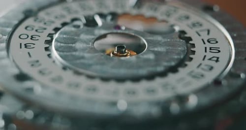 Slow motion close up of a professional watchmaker repairer working on a luxury mechanism watch gea