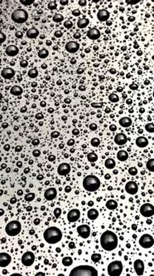 Monochrome Art of Water Drops Forming Circle Pattern on Black Mesh Surface