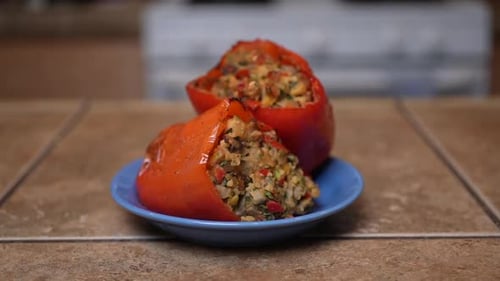 Stuffed sweet bell peppers on a plate and ready for that first mouthwatering bite - slow dolly forwa