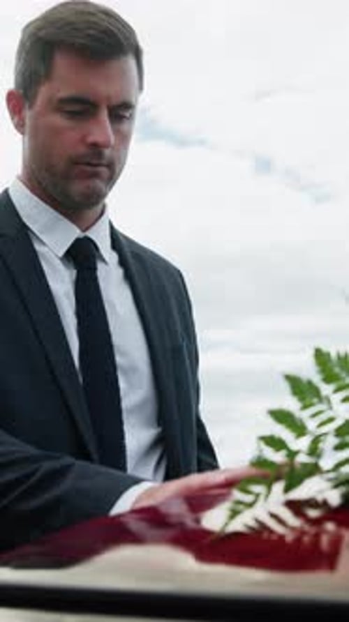 Sad, man and widower in graveyard with coffin, unhappy and grief for farewell ceremony and mourning
