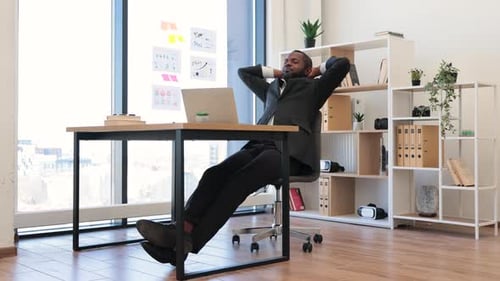 Afrikanischer Mitarbeiter mit Laptop ruht sich von der Arbeit im Büro aus