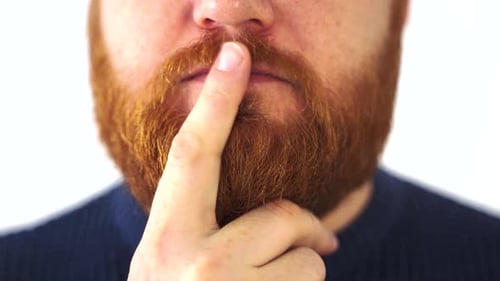 Man Signalling Silence With Finger to Lips
