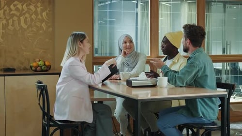 Multiethnic Business Team of Coworkers Discussing a Project While Sitting at the Bar During Lunch