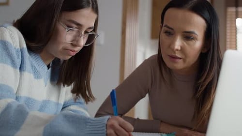Woman Helping Teen with Homework Indoors