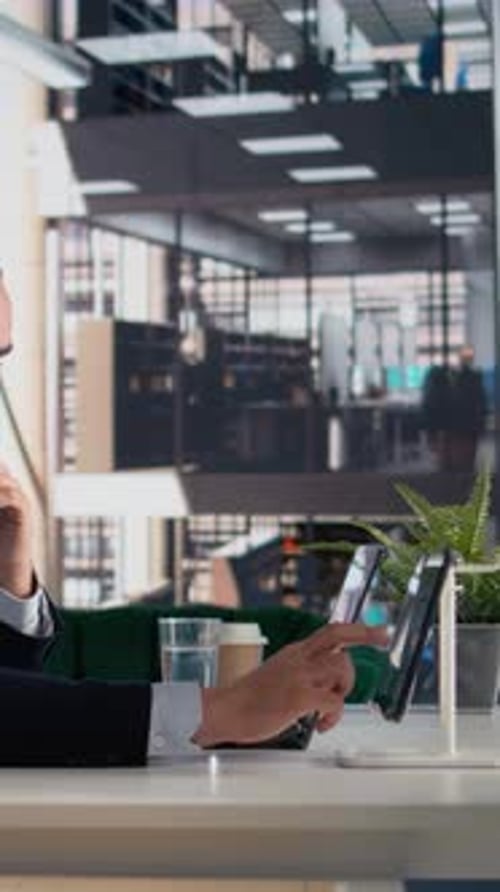 Businessman Working on Laptop and Tablet in Office