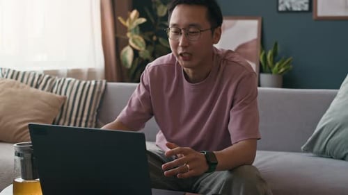 Freelancer Having Video Call on Laptop with Tea in Home Office