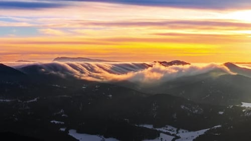 Golden Clouds Rolling Over Snowy Peaks