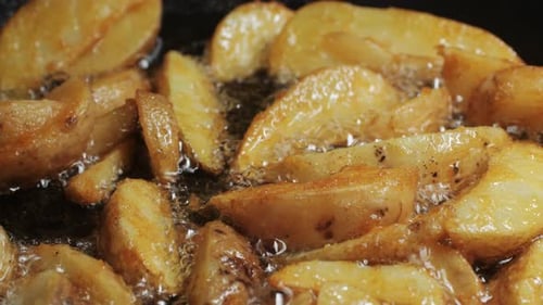 Potato Wedges Frying in Pan of Oil