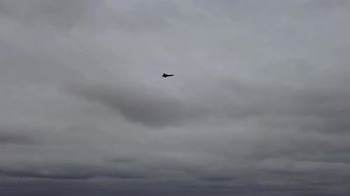 Jet Plane Flying Through Cloudy Sky