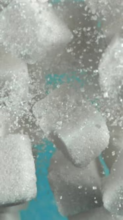 Cubes of Sugar Fly Up and Fall Down on a Blue Background Filmed on a Highspeed Camera at 1000 Fps