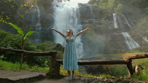 Woman Enjoys Waterfall in Tropical Forest
