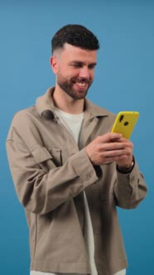Smiling Young Adult Using a Smartphone