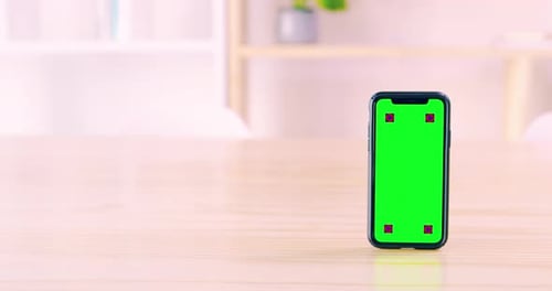 4k video footage of a smart phone with a green screen flipping to stand upright on a desk