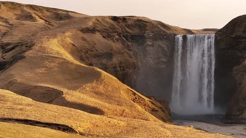 Waterfall scenery in Iceland with stunning Skógafoss and beautiful hills in the background