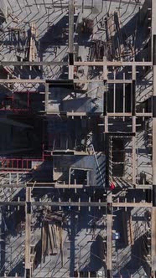Vertical Video of Engineers Reviewing Plans While Workers Build Foundations and Assemble Walls