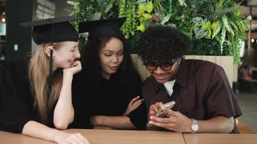 Young graduate students taking a selfie together at college.
