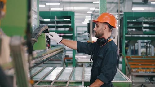 Production of the windows. Man is working in the modern factory.
