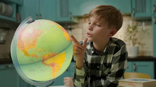 Boy Studying Geography with Globe at Home