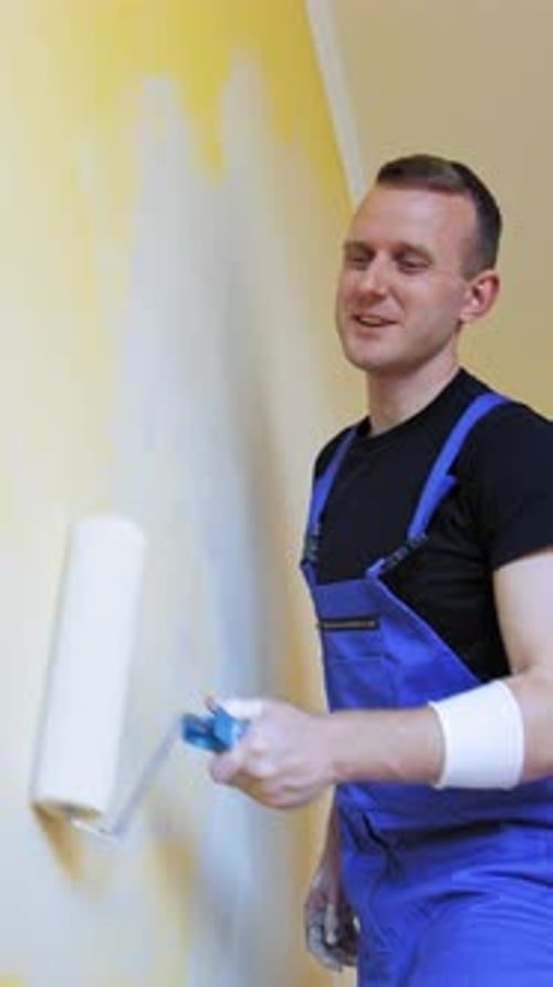 Young man improving apartment. Interior decoration in flat.