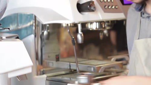 Barista Tamping Espresso Grounds in Cafe