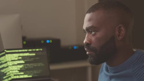 Programmer Working in Server Room at Night