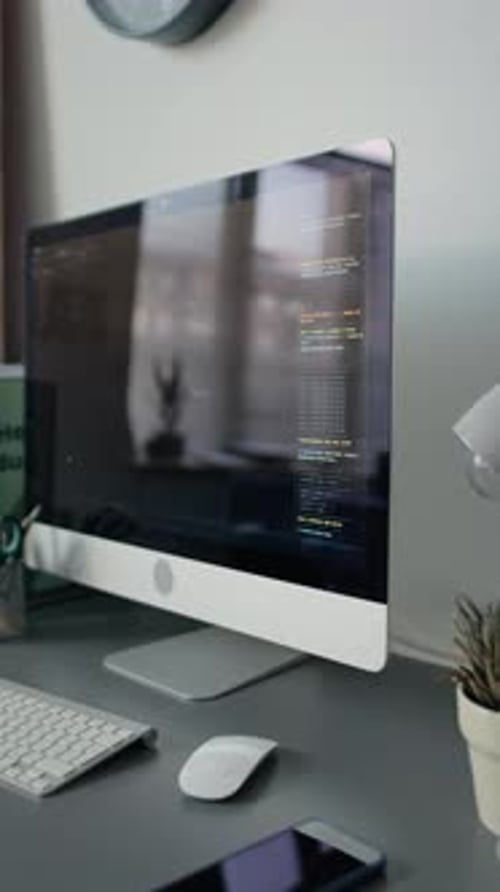 Moniteur de bureau affichant le code avec des dossiers et des fournitures