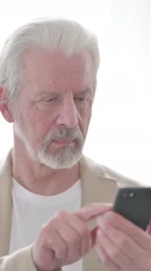 Senior Man Using Mobile Phone at Home