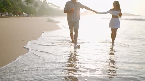 Man Woman in Love Walk Barefoot in Sea Surf Water Edge Reflection of Couple with Coconut Cocktails