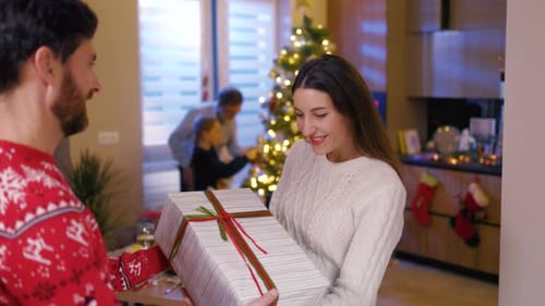 Beautiful Handsome Caucasian Couple Exchanging Holiday Presents at Home Their Family Members