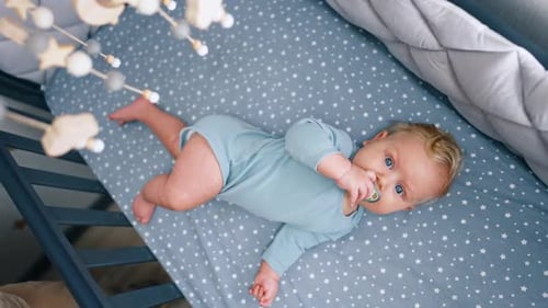 Baby Relaxing in Crib with Mobile