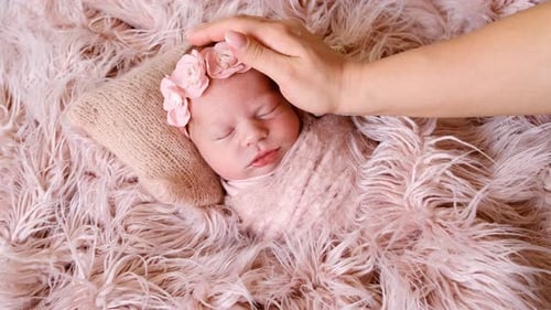 Newborn Baby Sleeps Peacefully with Gentle Touch