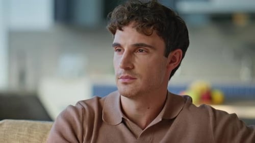 Man With Curly Hair Drinks From Blue Mug