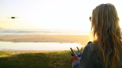 Frau pilotiert Drohne in der Natur, Flug und Quadrocopter am See, Spionage oder Videoüberwachung bei Sonnenuntergang
