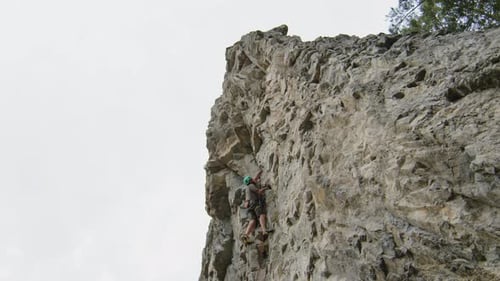 Man Climbing Steep Rock on Summer Day