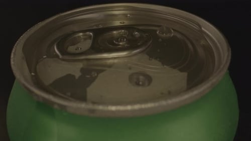 close up of droplets on top of spinning soda can